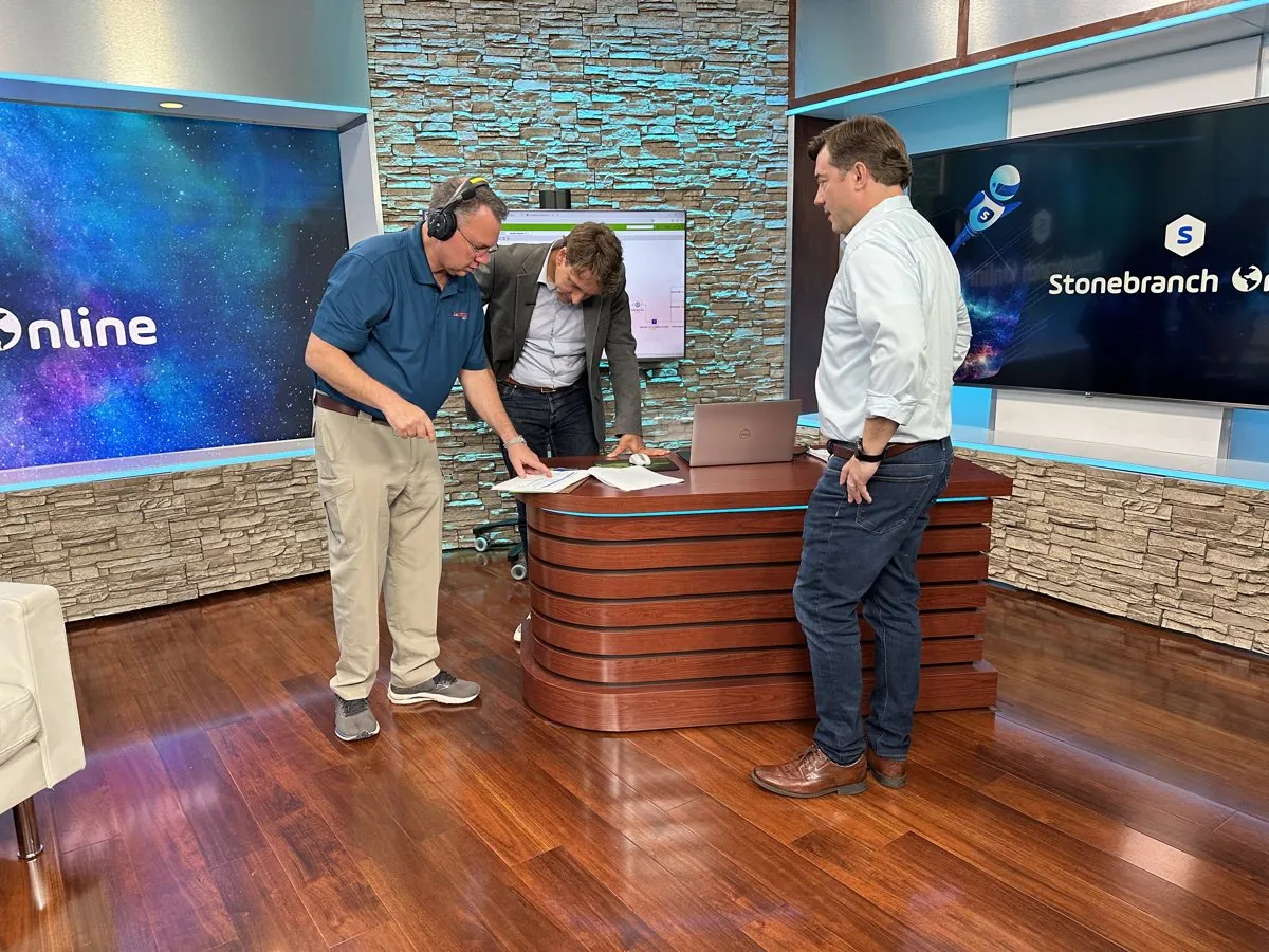 Production team preparing a branded studio set for an executive video recording