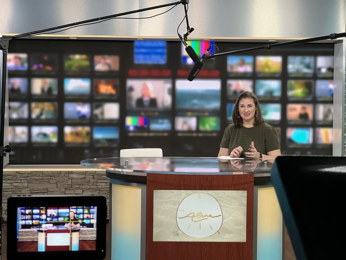 Corporate presenter recorded with studio microphones, camera monitoring, and a branded set