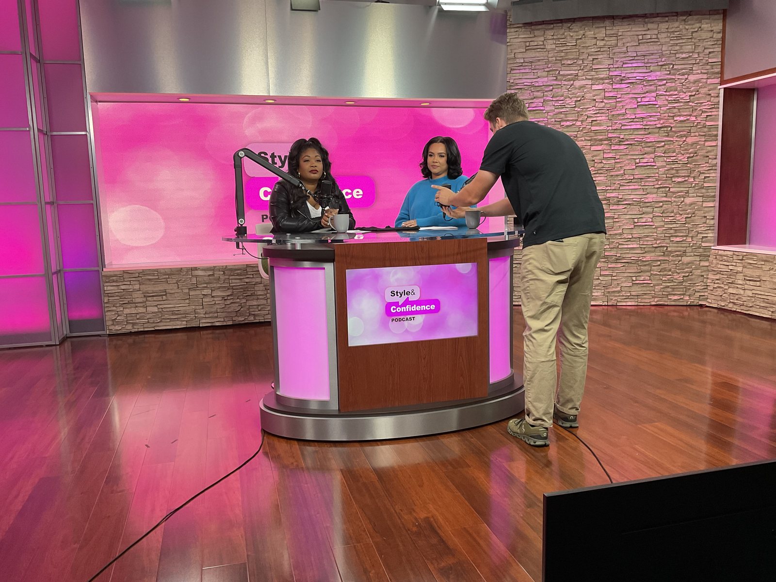 Producer preparing presenters on a branded video podcast set